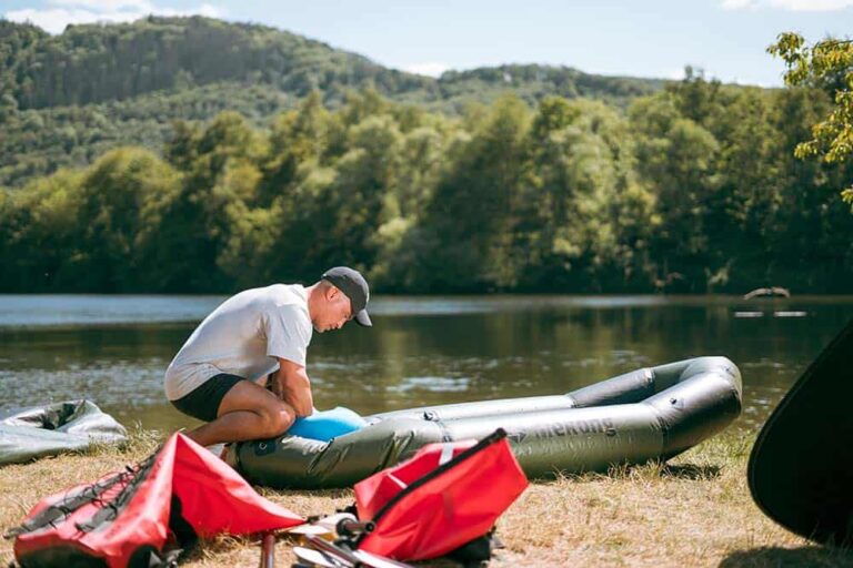 Person inflates an inflatable packraft.