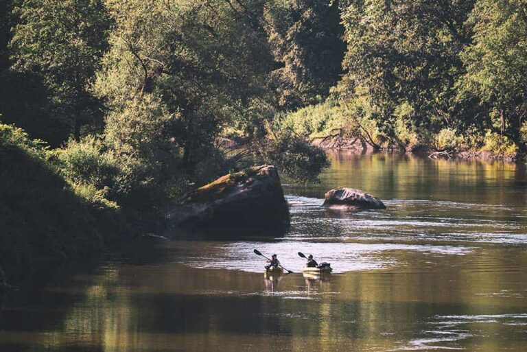 Two friends explore a river in their packrafts.