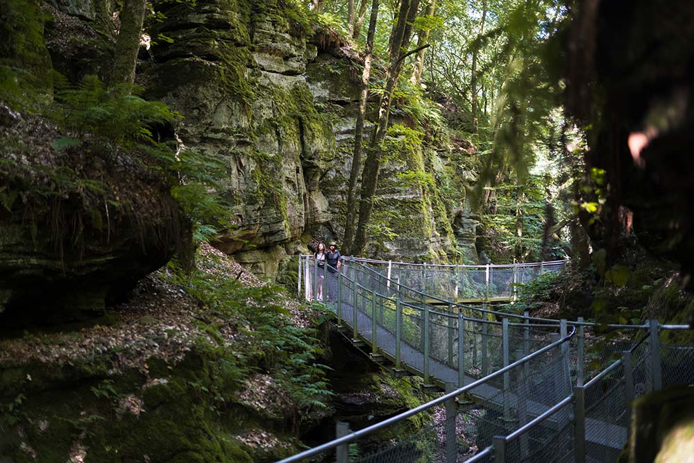 2 people walk across the bridge Ruetsbech Müllerthal trail