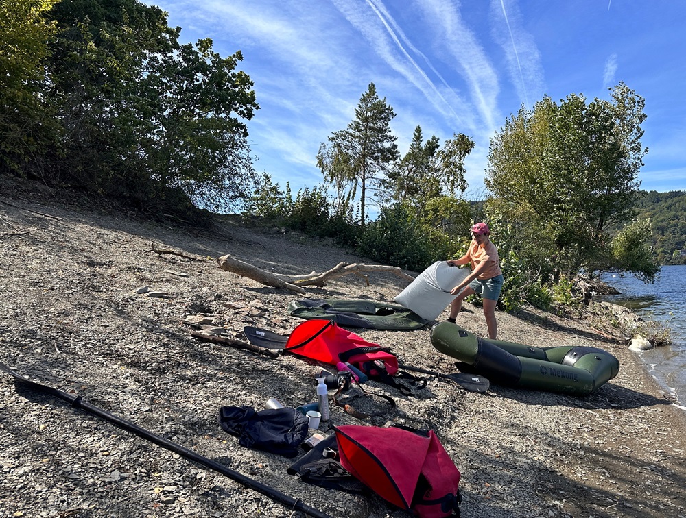 Inflating a packraft on the lakeshore during a packrafting adventure in the Eifel Germany